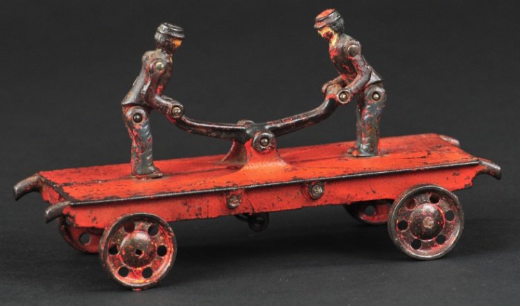 IDEAL ARTICULATED HANDCAR: Cast iron, painted in red, features two figures holding hands with articulated action and causing each to bend forward and upright in unison. 7 3/4" l.
