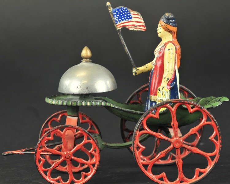 MISS LIBERTY BELL TOY: Kyser & Rex, very rare bell toy, hand painted overall and molded in cast iron, features Miss Liberty figure standing on ornately cast platform shared by bell with finial. 8" l.