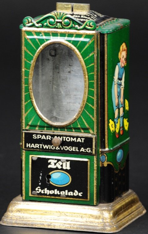 VENDING BANK - "LEU": Hartwig & Vogel, Germany, circa 1920, lithographed tin, oval glass view panel on front panel, bright graphics, deposit coin and open drawer for candy retrieval. 5 1/2" h.