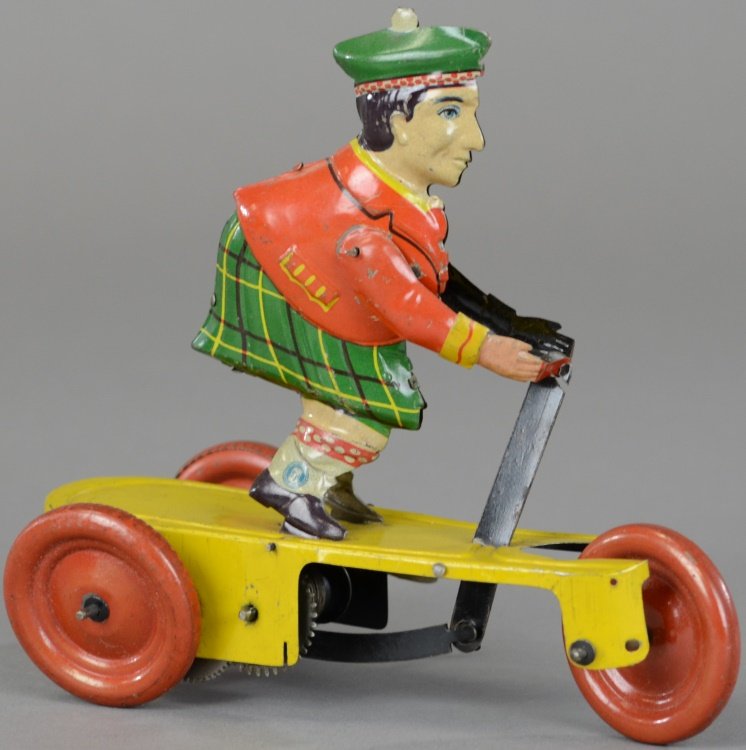 SCOTSMAN ON SCOOTER: Gunthermann, Germany, c. 1922, scarce example, lithographed tin, features figure in kilt standing on three wheeled scooter, wind-up action, done in yellow base with red disc wheels. 7 1/4" l.
