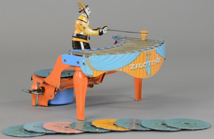 ZILOTONE: Wolverine Mfg., tin and pressed steel musical toy depicts figure at play on zilotone, colorful keyboard, orange instrument, clockwork mechanism activates spinning records and drumming motion by figure