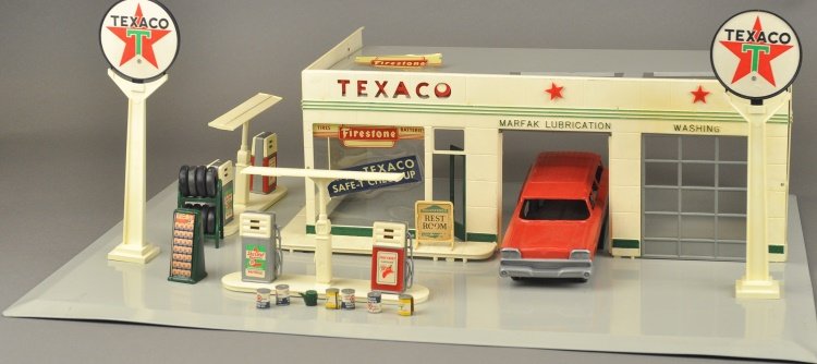 BUDDY 'L' TEXACO TOY SERVICE STATION: Service station done in plastic and metal base, many tabs are broken but set is mostly complete with original auto and sleeve box, instruction sheet included but torn. 24" x 18".