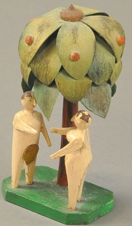 ADAM AND EVE UNDER TREE DISPLAY: Germany, c. 1860, carved and hand painted wood with wood shaved leaves applied to central tree, each figure depicted in fig leaf attire and appears to reach for each others hand. 4 1/2" h.