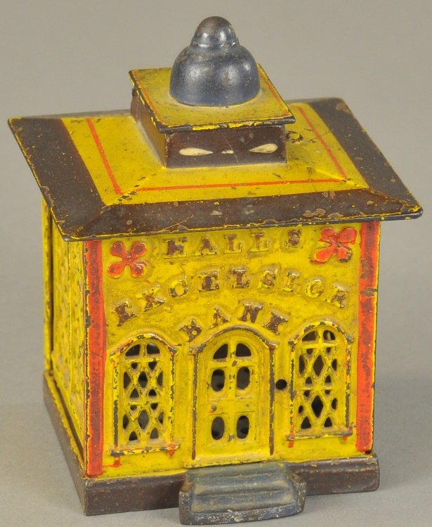 HALLS EXCELSIOR MECHANICAL BANK: J. & E. Stevens Co., designed by John D. Hall, Patented 1869, when pulling knob, a door opens at the top of this bank, a cashier figure appears to receive the deposit, this then allows door to fall ba