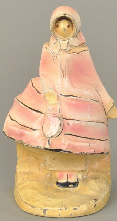 OLD FASHIONED LADY DOORSTOP: Marked, "Hubley 296," cast iron, pink dress version, great deco design of woman in hooded hoop dress, very rare with strong colors. 7 3/4" x 4".