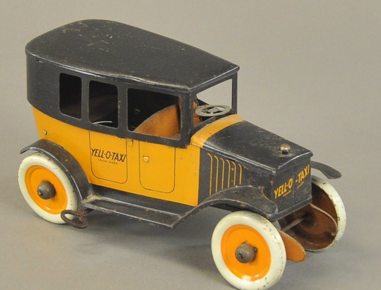 STRAUSS YELL-O-TAXI: Lithographed tin, done in orange and black colors, wind-up action, seated driver, disc wheels, early styled cab model. 8" l.