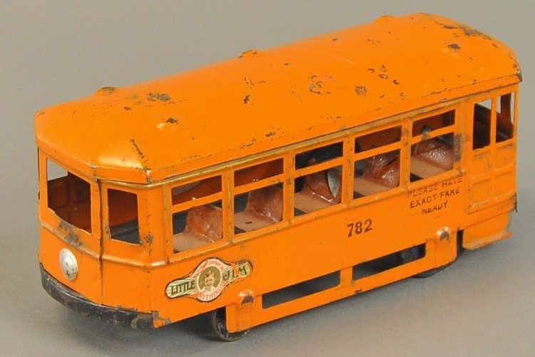 KINGSBURY SUBURBAN TROLLEY CAR: c. 1924, No. 782, pressed steel, painted in orange overall, "Little Jim" decal on side, interior bench seating, clockwork driven, rubber tires on rear. 9" l.