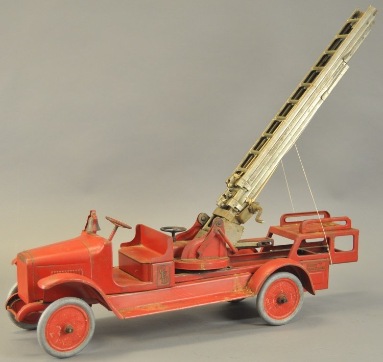 BUDDY 'L' AERIAL LADDER TRUCK: c. 1925, pressed steel, done in red overall, nickel ladder, full length running boards, brass bell, ladder extends 4 1/2 feet, small hand wheel will rotate ladder, hydraulic lift model. 36" l.