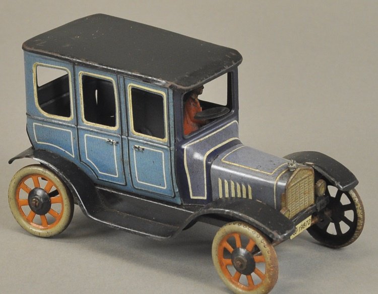 BING SEDAN: Germany, lithographed tin, blue body, black roof and running boards, seated driver, spoke wheels and clockwork driven. 6 1/2" l.