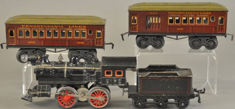 BING 'O' GAUGE TRAIN SET: Germany, cast iron, 0-4-0 electric American Outline locomotive and six wheel tin tender, together with two #5208 and #5285 Pennsylvania Lines litho cars in brown bodies. 5 1/2" - 9" l.