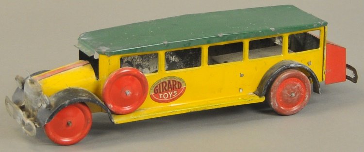 GIRARD TOY BUS LINE: Lithographed tin, done in red, yellow and green with yellow trunk, disc wheels, clockwork driven, side decal reads, "Girard Toys - Making Childhood's Hour Happier." 14" l.