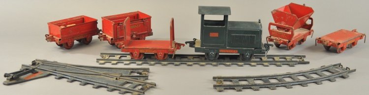 BUDDY 'L' INDUSTRIAL TRAIN SET: Pressed steel, includes green locomotive, red train rack car, stake car, coal car, ballast car with hinged doors, dump car and twelve pieces of original track. 6 1/2" - 10" l.