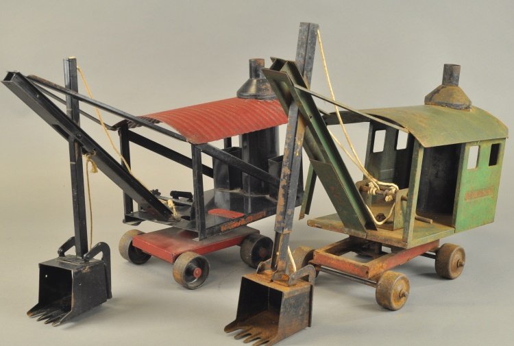 TWO PRESSED STEEL STEAM SHOVEL TOYS: Lot includes: Buddy 'L' Steam Shovel, and a Sturditoy Construction Co. Steam Shovel in green, both show extensive play wear, some corrosion. 19" - 20" l.
