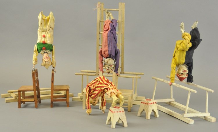 AUTO CIRCUS PERFORMING CLOWNS: France, c. 1930, features two mechanical and two non-mechanized clowns, each in cloth outfits, hand painted composition heads, some able to stand on wood chairs, ladder or parallel bar. 10" l.