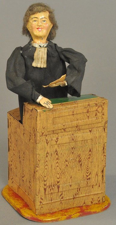 THE FERNAND MARTIN ADVOCATE: France, lithographed tin podium with standing figure, hand painted tin head, wears full cloth suit, when clockwork is activated, figure begins to raise arms and turn body from side to side while holdi
