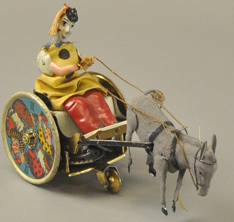 LEHMANN BALKY MULE: Germany, a signature toy for the company, lithographed tin, amusing clown figure rides comical cart, colorful wheels with strong graphic images, clockwork driven. 7 1/4" l.