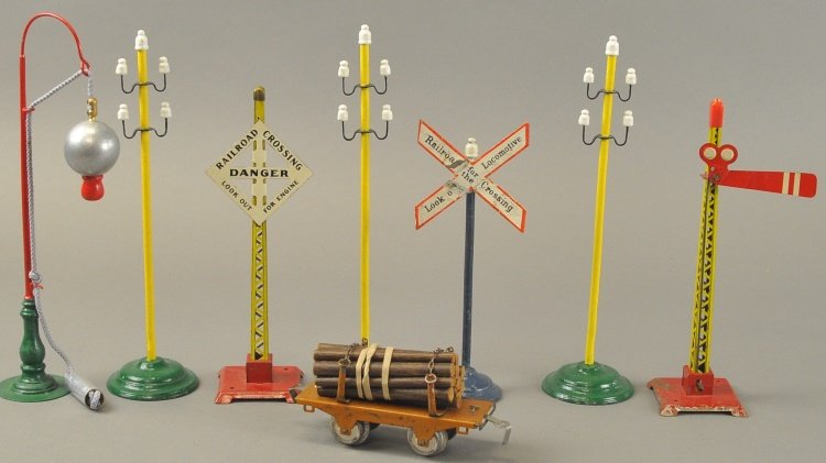 GROUPING OF TRAIN ACCESSORIES: Lot includes three Marklin telegraph poles, American semaphore and danger sign, railroad crossing sign, lamp pole and small Ives log car.
