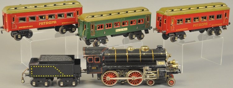 FANDOR '1' GAUGE TRAIN SET: Rare set with low production, includes #1026 4-4-0 electric driven with eight wheel tin tender and three passenger cars, two in red, one in green tin litho body, all with passenger figures at windows.