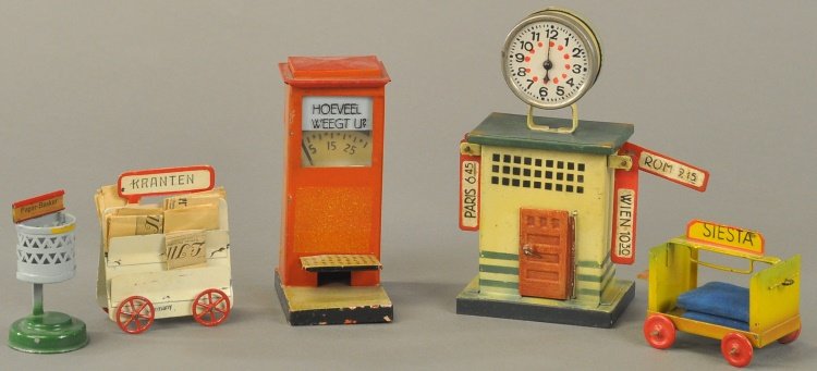 LOT OF FIVE TRAIN ACCESSORIES: Germany, includes: Kibri Station scale "Test your weight," clock stand with destination boards, and trash basket stand, "Siesta" rolling cart and News stand cart. 3" - 5" h.
