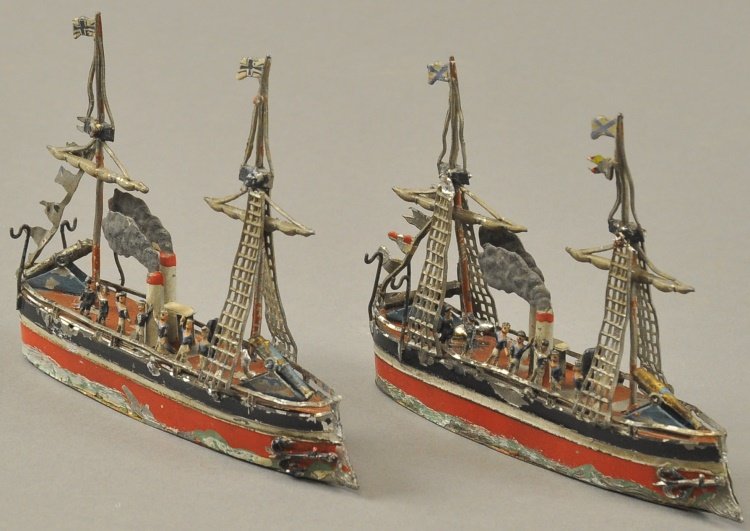 LOT OF TWO GERMAN WARSHIPS: Hand painted lead, each features a row of sailors on deck, two masts, three with ladders, twin stacks with smoke, signed flags, guns fore and aft, and red, black and green hulls. 5" l.