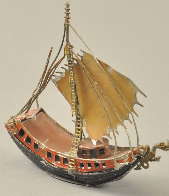 CHINESE JUNQUE: Maker unknown, lead example, has Heyde qualities, hand painted overall with ornate sails, single masted vessel is painted in black and red hull, brown deck and yellow sails. 5" l.
