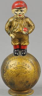 MASCOT STILL BANK: Hubley, Lancaster PA, cast iron, circa 1915 Scarce and desirable bank, features young baseball player standing atop a baseball, painted in gold overall with red stockings and cap, debossed American Le