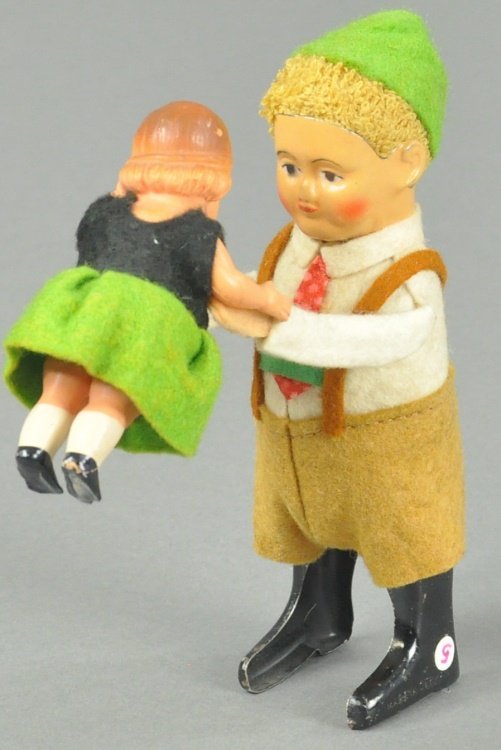 SCHUCO TYROLIAN DANCING COUPLE: Germany, c. 1937, both depicted in full outfit, boy made of tin, girl has celluloid arms and head, clockwork. 5" h.