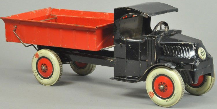HERCULES LIFT DUMP TRUCK: Chein, c. 1920's, pressed steel, low open Mack cab painted in black, red dump body tilts for unloading, metal wheels. 18" l.