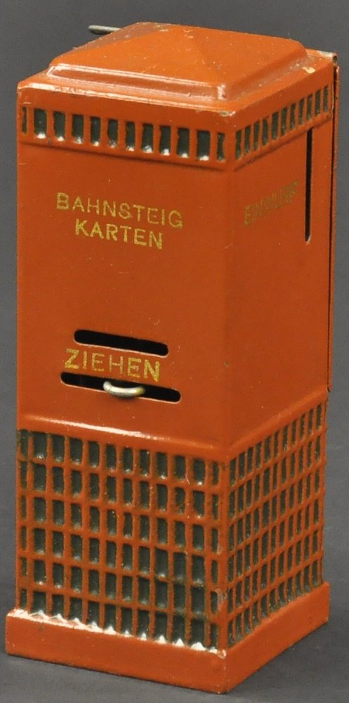 MARKLIN BAHNSTEIG KARTEN MONEY BOX: Germany, hand painted, done in brown color overall, embossed pattern once dispensed, coin slot lettered, "ZIEHEN." 5 1/2" h.