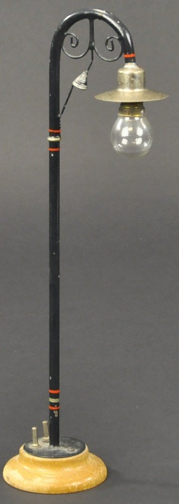MARKLIN GAUGE I ELECTRIC STREET LAMP: Germany, all original, painted in black, pole with nickel shade, glass bulb, electric pole on wooden base. 11 1/2" h.