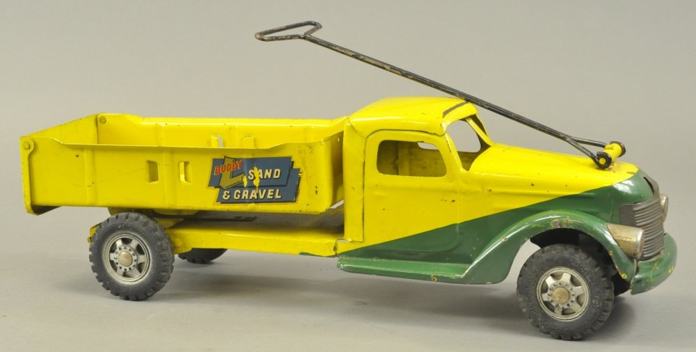 BUDDY 'L' SAND & GRAVEL TRUCK: 1949, pressed steel, duo-tone colors yellow and green, nickel plated grille and lights, black pull handle and rider seat, catch lever on side painted in yellow, tilting action springs back, decals rea