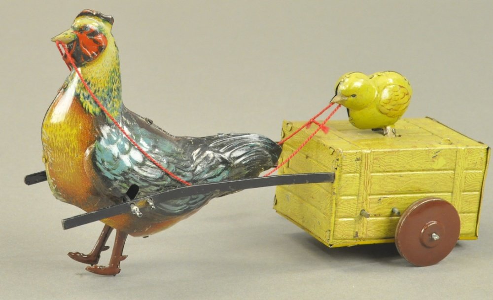 HANS EBERL HEN AND CHICK CART: Germany, lithographed tin, depicts large hen pulling simulated tin wooden crate with small chick at top which pecks as it is pulled along, clockwork driven. 9" l.