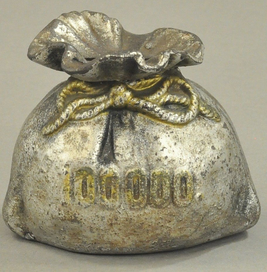 $100,000 MONEY BAG STILL BANK: Cast iron, marked $100,000, trap on bottom, made in early 1900's, hard to find bank. 3 1/2" h.