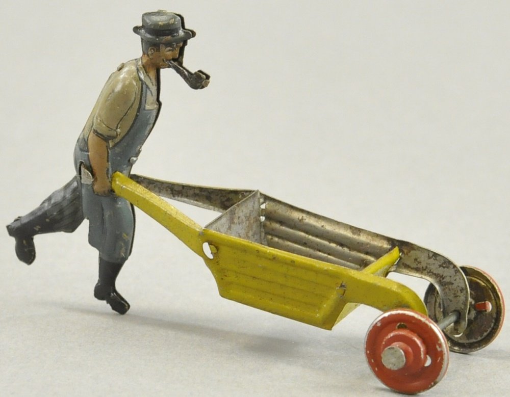 MAN WITH PIPE PUSHING WHEELBARROW PENNY TOY: Unknown mfg. and unmarked, features man with broad rimmed hat smoking a pipe, wearing blue overalls, black boots and sleeves rolled up, pushing yellow wheelbarrow. 3" l.