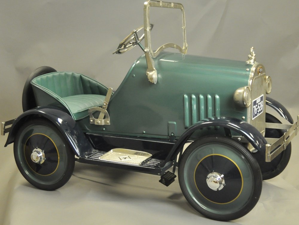 CADILLAC PEDAL CAR: Pressed steel, painted in deep green with black full fenders, appears to be an American National, original body with re-manufactured parts. [Oversized freight required] 38" l.