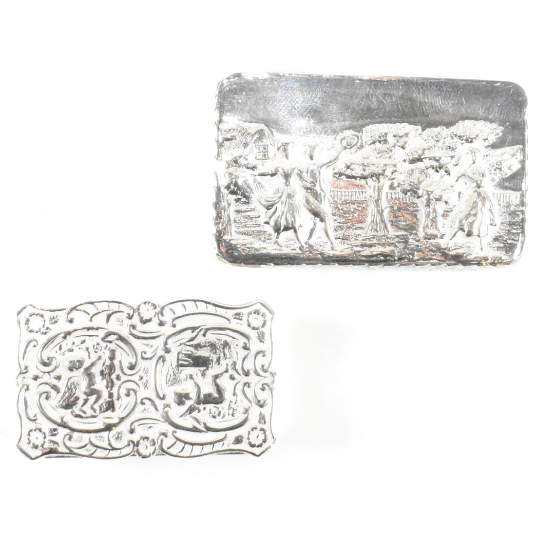 HALLMARKED SILVER A MARSTON & CO SILVER SNUFF PILL BOXES: Hallmarked silver A Marston & Co rococo relief cast pair of silver snuff / pill boxes. One with scene of couple, the other with scroll work design. Hallmarked Birmingham, date letter W for 1971. G