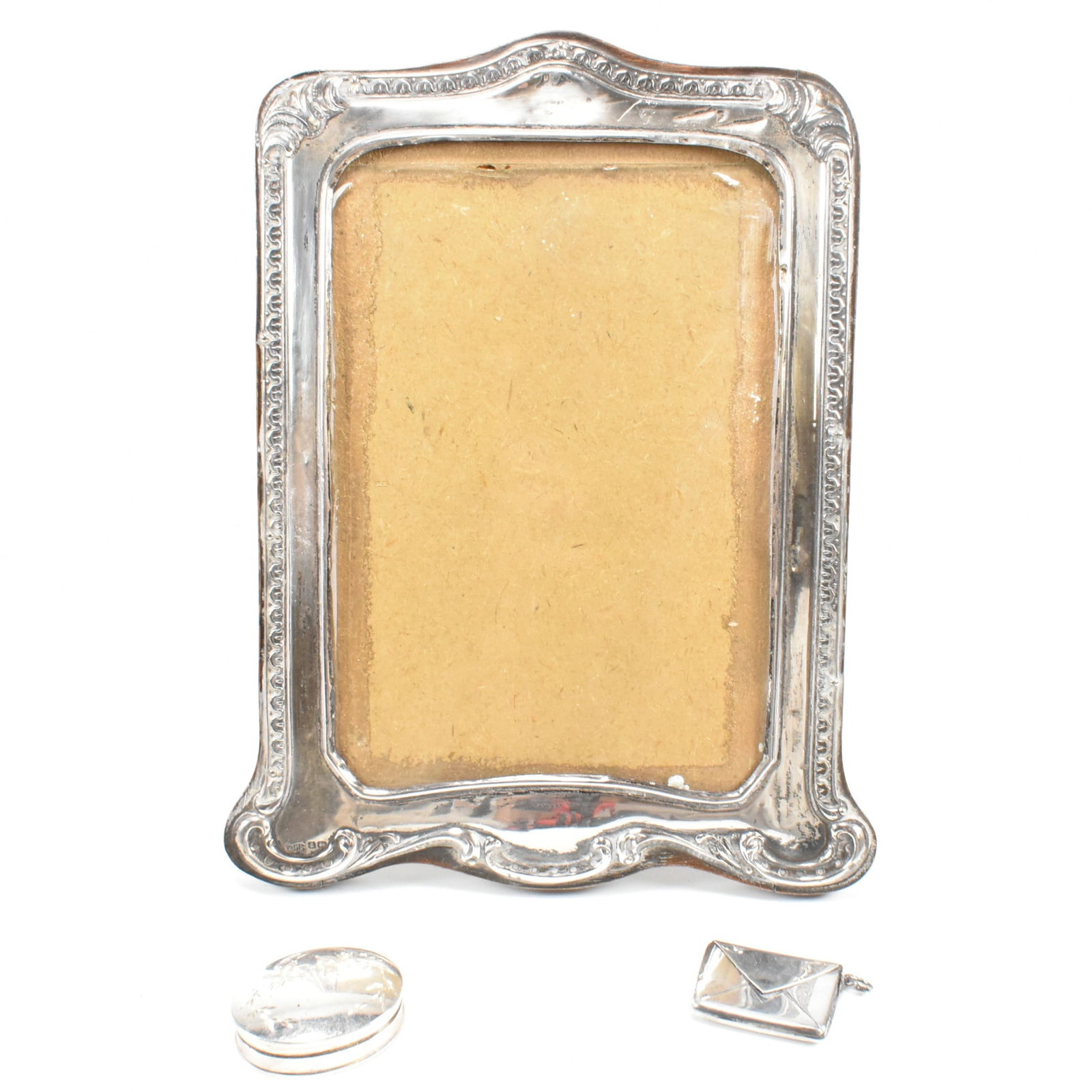 HALLMARKED SILVER PHOTO FRAME STAMP CASE & PILL BOX: A hallmarked silver mounted easel photo frame, hallmarked Birmingham, 18.5cm. An early 20th century hallmarked silver stamp envelope case, Hallmarked Birmingham 1911 makers mark WV&S, 3cm. A