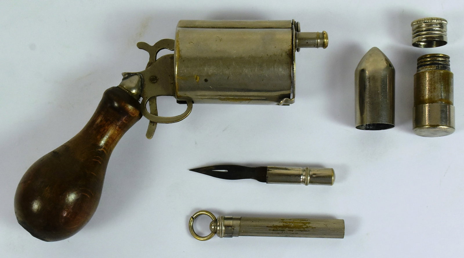 19TH CENTURY NOVELTY INK WELL REVOLVER: A small 19th Century novelty ink well writing compendium in the form of a revolver. Turned wood handle containing a small silver plated dip pen and the chamber holding a bullet shaped ink well. Fragil