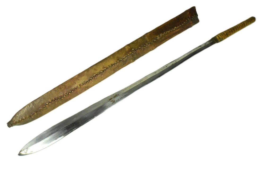 EARLY 2OTH CENTURY KENYAN MAASAI PEOPLE MACHETE: An early 20th Century East African Kenyan Maasai People Seme Alem / Machete knife. Sinew wrapped handle with a tapering blade widening at the tip. Housed in a stitched leather scabbard. Measures appro