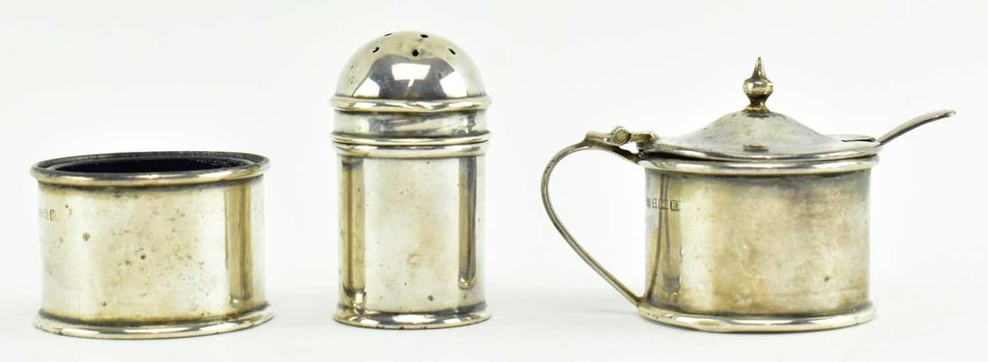 GEORGE V THREE-PIECE HALLMARK SILVER CONDIMENT SET: Three-piece silver hallmarked condiment set. The set to include a mustard pot, a salt cellar and a pepperette. Hallmarked year 1929 Birmingham, sponsors mark JR, with blue glass liners. Total gross we