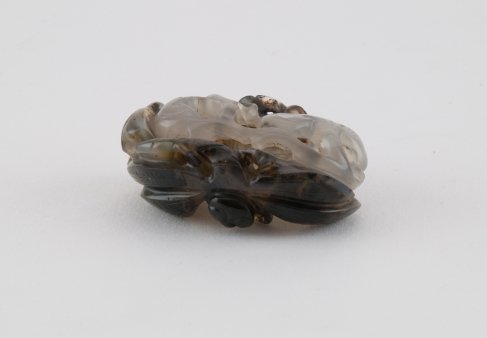 Netsuke: Jade, insect on floral background. China, 20th century. Length 4 cm.