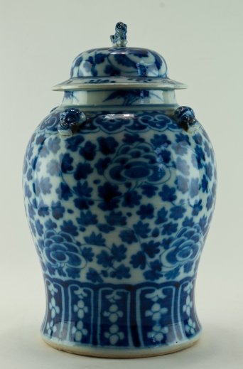 Chinese pot: Porcelain. Blue white decoration of flowers. Lid crowned with Fu dog. Height 37 cm. China, late 19th century.