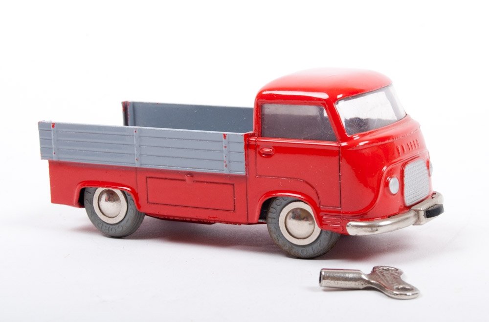 Schuco Varianto 3047: Red fire truck with key, matching thread, box and manual. 10,5 x 3,5 x 3,8 cm. In very good condition. + Schuco 1049, Ford FK 1000. In red with grey loading platform. Rear lid missing, else in very go