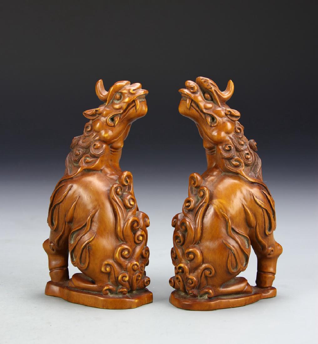 Pair of Chinese Boxwood Beasts: China, a pair of expertly boxwood carved beasts, both faces looking over right and left shoulders respectively. Height 5 in.