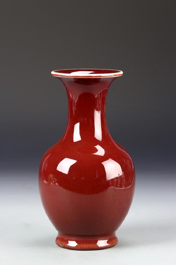 Chinese Oxblood Vase: China, 19th century oxblood vase, on a raised base, with rounded shoulders, long neck, and everted rim, glazed with a smooth, high shine surface. Height 8 1/2 in.