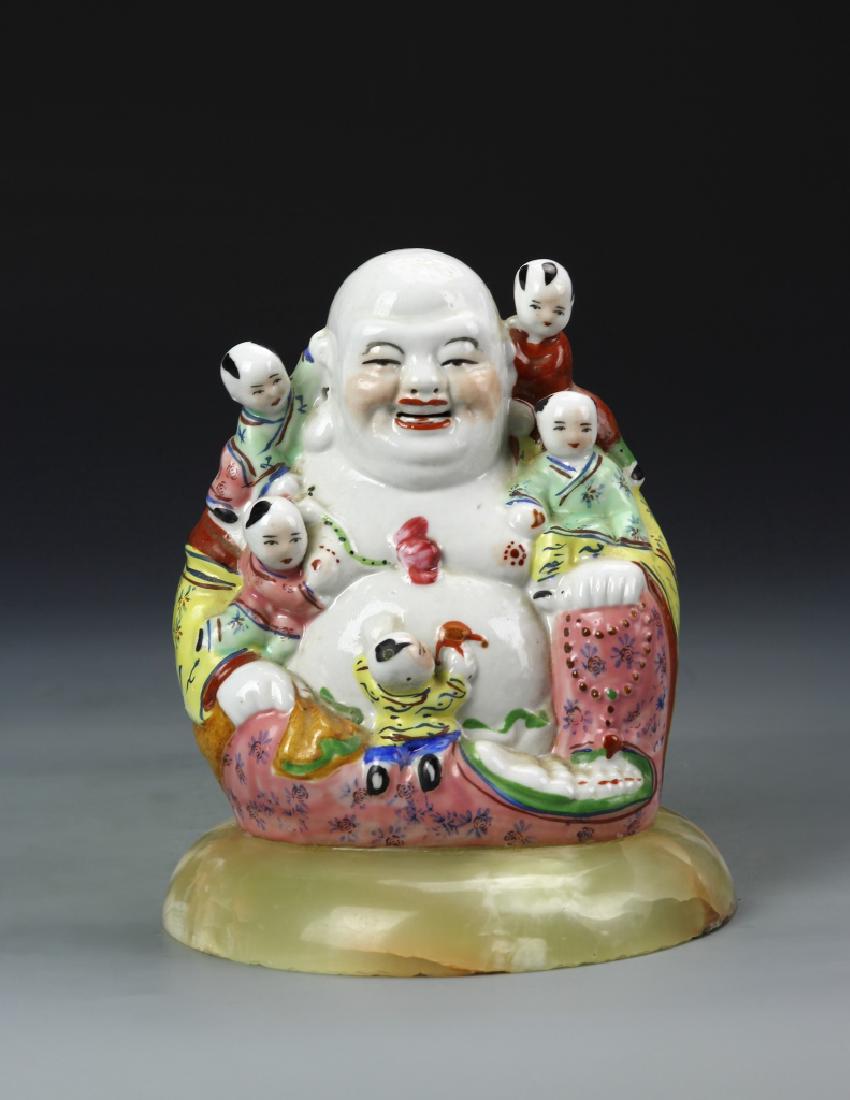 Chinese Famille Rose Buddha: China, 19th C., Famille Rose Buddha, in a seated position, with children climbing on his lap and shoulders, a white hued body with brightly colored robes, on a circular attached base in a mottled yell