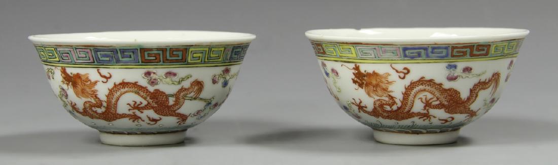 Pair of Chinese Famille Rose Bowls: China, a pair of Famille Rose bowls, with scrolling red dragon motifs across the surface, and colorful key-fret detail around the rim, mark on base, chip on rim. Width 3 5/8 in., Height 1 5/8 in.