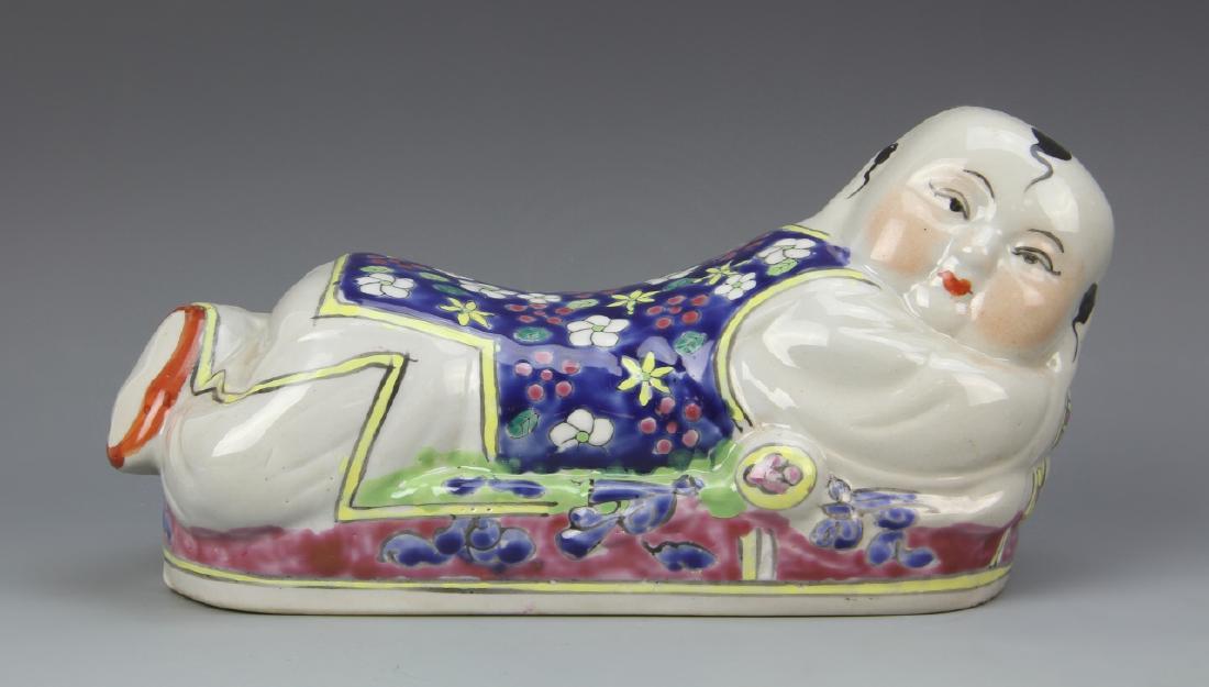 Chinese Famille Rose Doctors Palm Reading Pillow: China, ROC Period, Famille Rose doctors palm reading pillow, in a reclining position, with brightly colored floral motifs and clothing. Length 9 in.