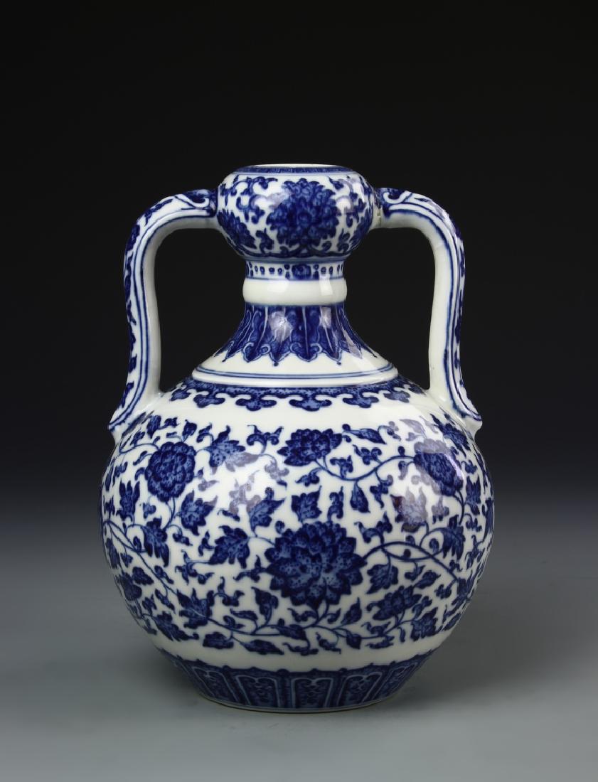 Chinese Blue and White Vase: China, 19th C., blue and white vase, small round mouth, connected to body by decorative curving handles, decorated throughout in blue floral designs and feather borders, Qianlong mark on base. Height