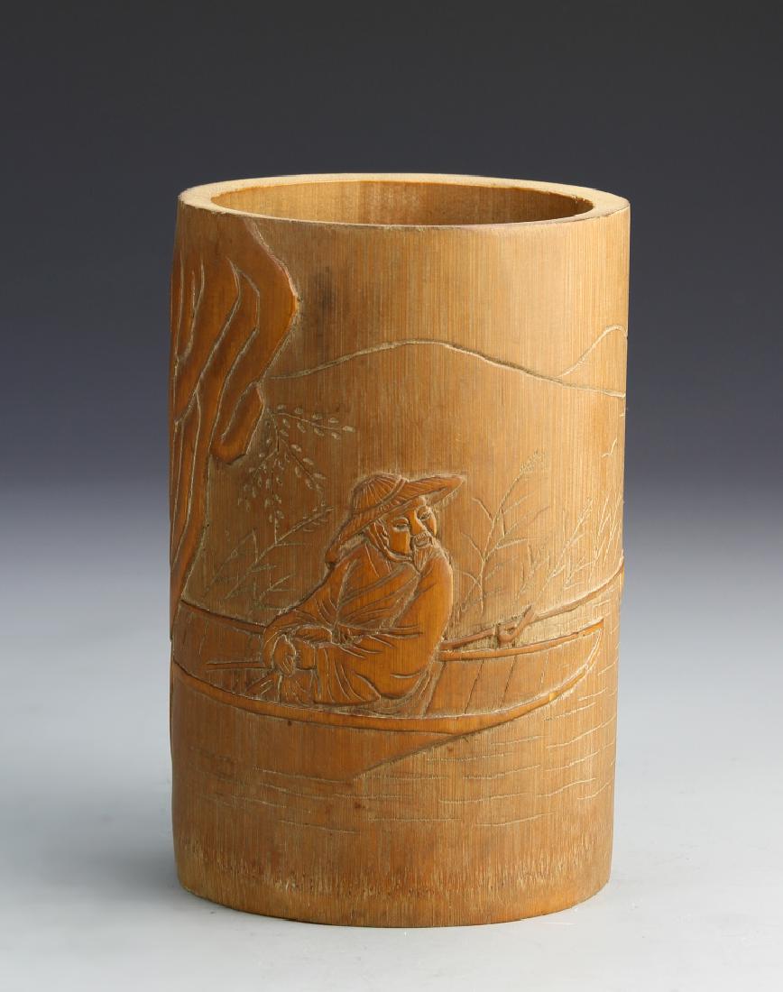 Chinese Bamboo Brush Pot: China, bamboo brush pot with incised depiction of smiling man in a boat sailing along a river, with calligraphy on back. Height 6 1/4 in.14422